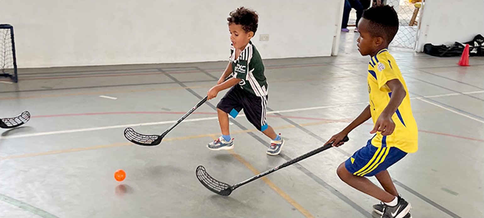 Two students facing off with floorball sticks during a Hockey Jams lesson